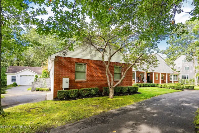 a front view of a house with a yard and trees