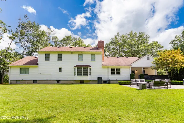 an aerial view of residential houses with outdoor space and trees