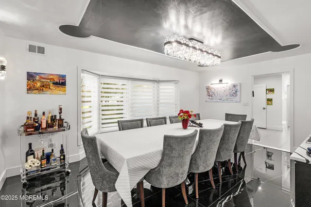 a view of a dining room with furniture and chandelier