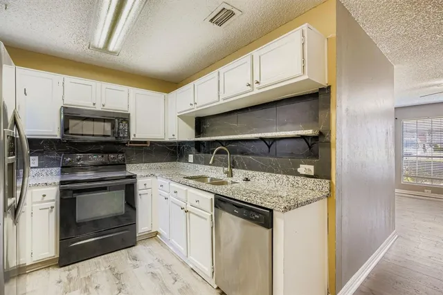 a kitchen with stainless steel appliances granite countertop a sink stove and microwave