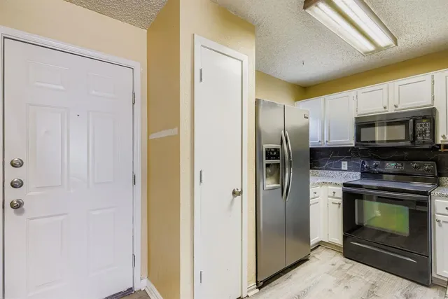 a kitchen with a refrigerator stove and cabinets