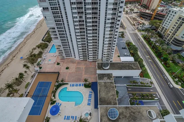 a view of a dining room with furniture a chandelier and wooden floor