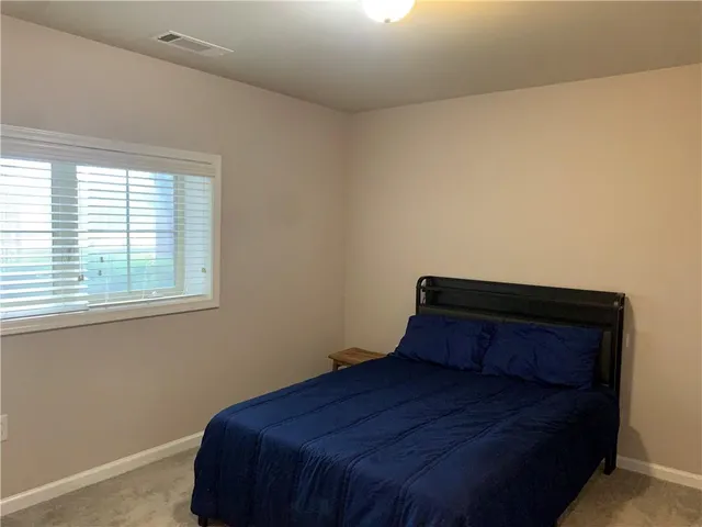 a bed sitting in a bedroom next to a window