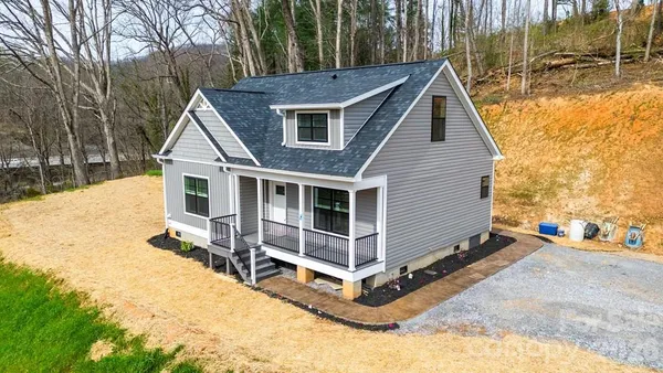 a view of a house with a yard and wooden fence
