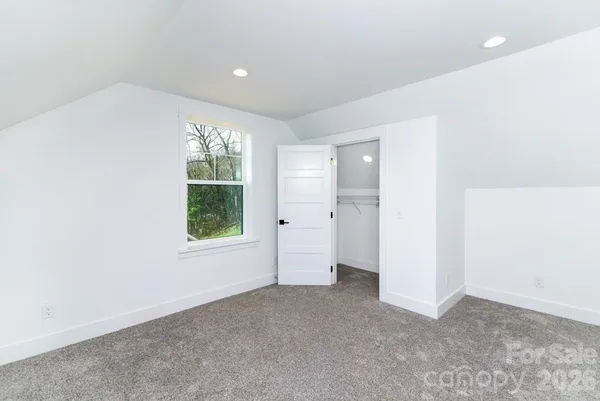 an empty room with windows and closet