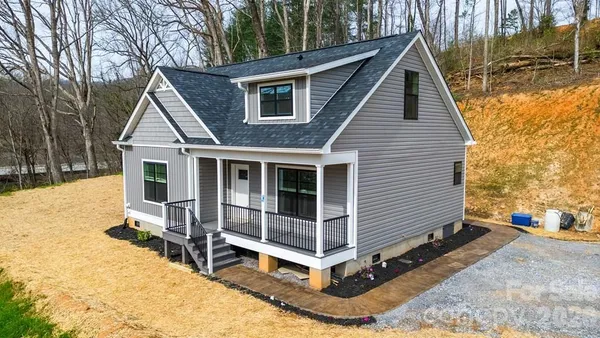 a view of a house with a yard and wooden fence