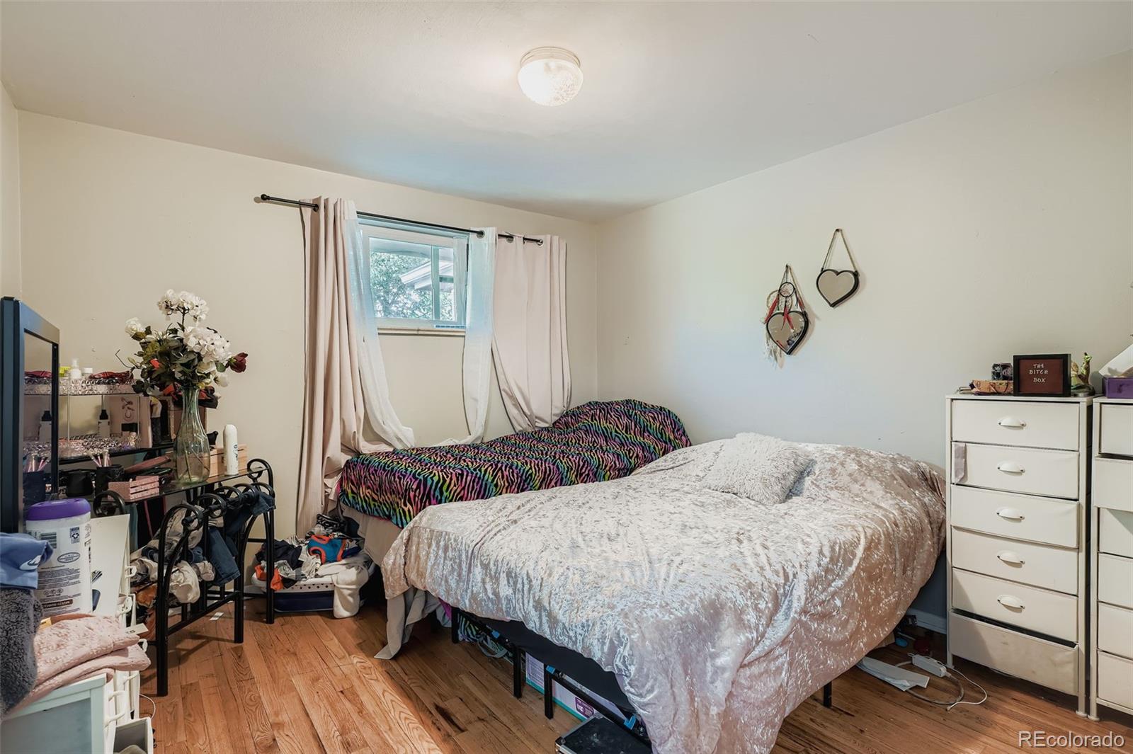 8805 West 46th Avenue Wheat Ridge, CO 80033 - Photo 17 of 25 a bedroom with a bed and wooden floor
