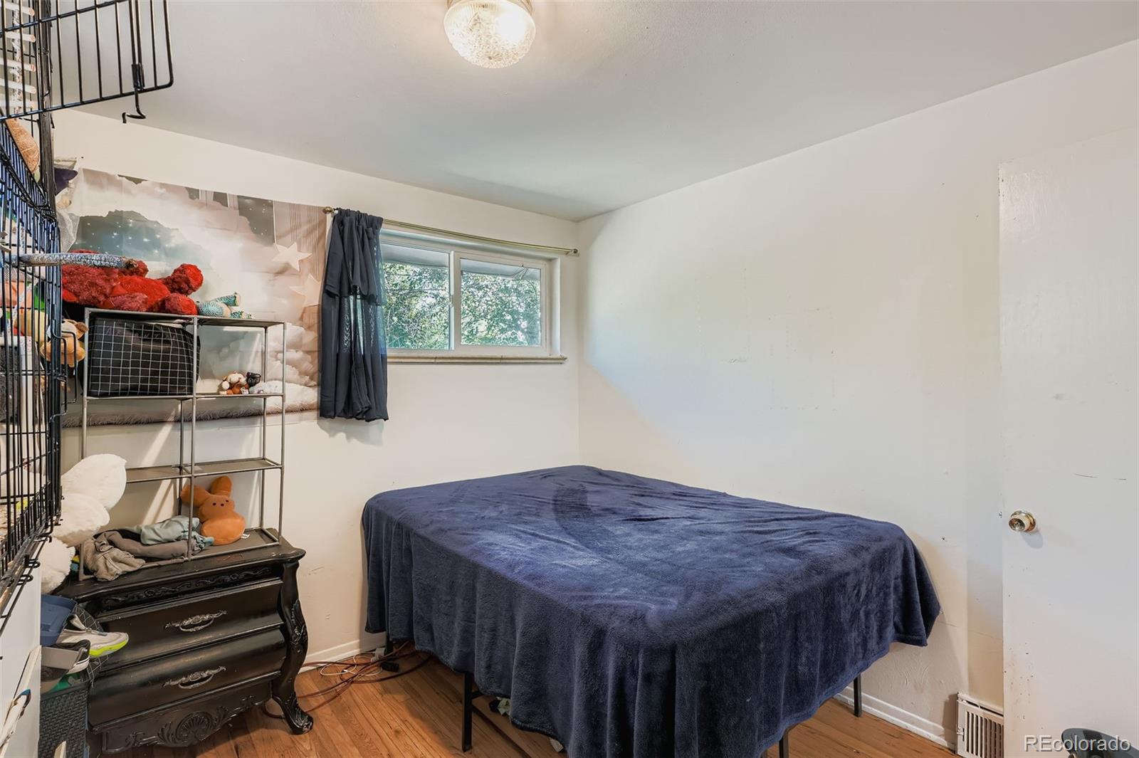 8805 West 46th Avenue Wheat Ridge, CO 80033 - Photo 20 of 25 a bedroom with a bed and a flat screen tv