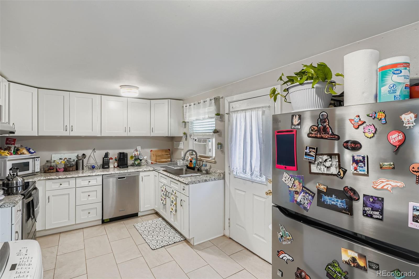 8805 West 46th Avenue Wheat Ridge, CO 80033 - Photo 6 of 25 a kitchen with stainless steel appliances granite countertop a sink and cabinets