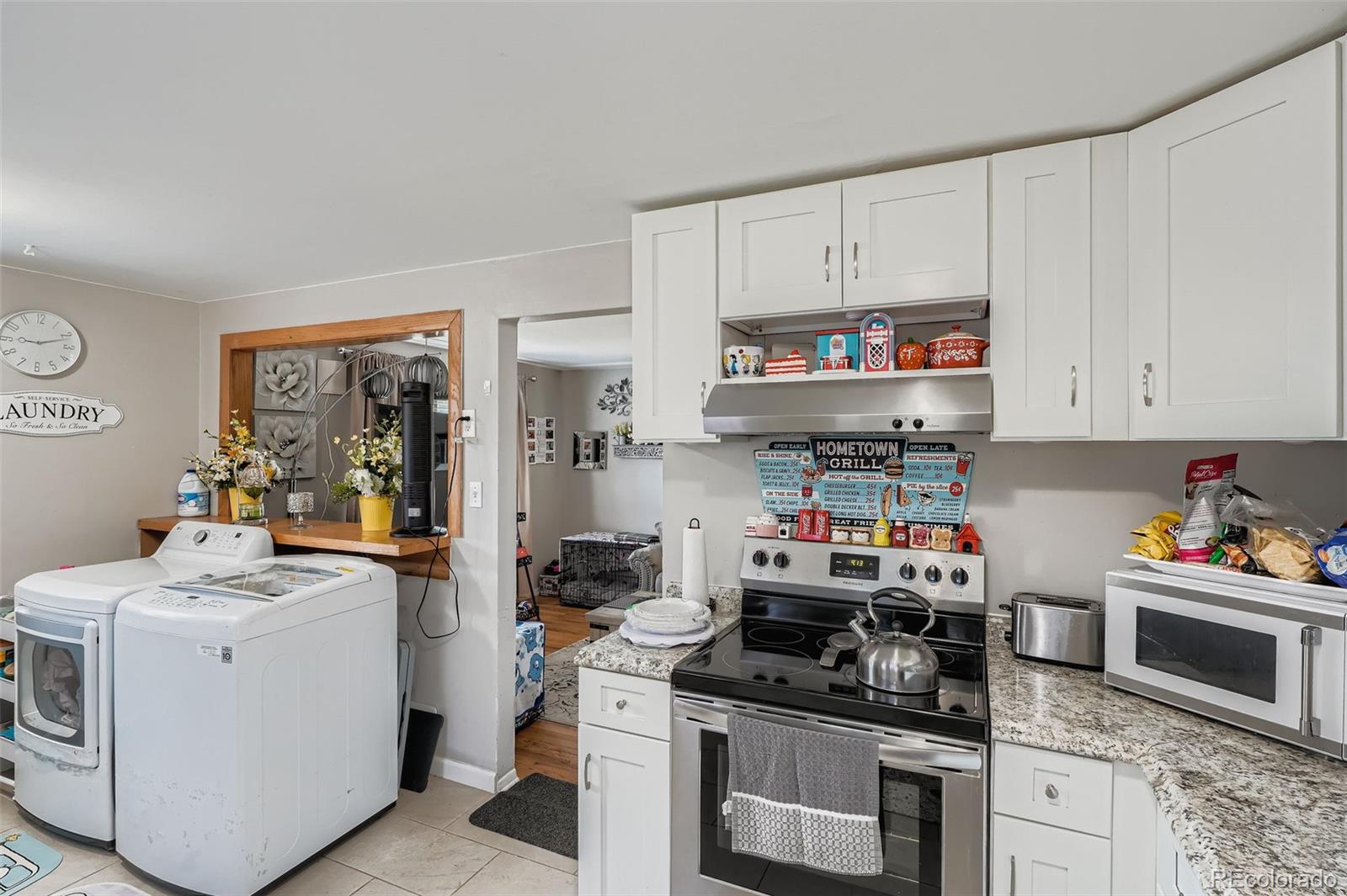 8805 West 46th Avenue Wheat Ridge, CO 80033 - Photo 7 of 25 a kitchen with stainless steel appliances granite countertop a stove and a refrigerator
