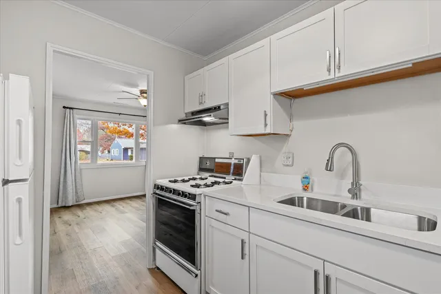 a kitchen with stainless steel appliances a white stove top oven and sink