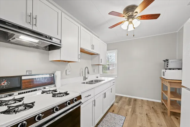 a kitchen with stainless steel appliances a sink a stove and a wooden floors