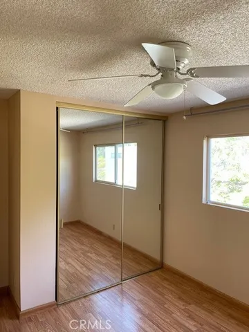 en empty room with wooden floor fan and windows