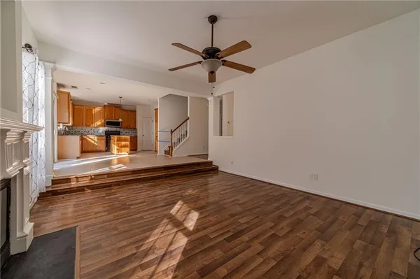 a view of a hallway with wooden floor and a chandelier