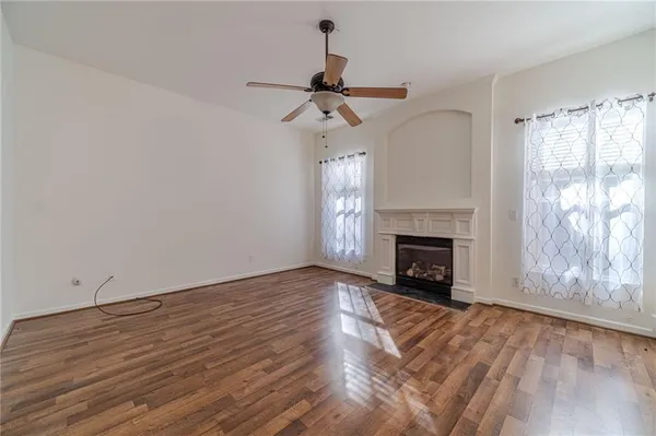 a view of a livingroom with wooden floor a fireplace and window