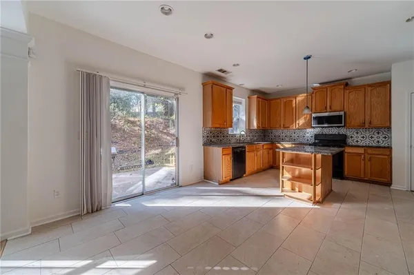 a kitchen with granite countertop a stove top oven a sink and cabinets
