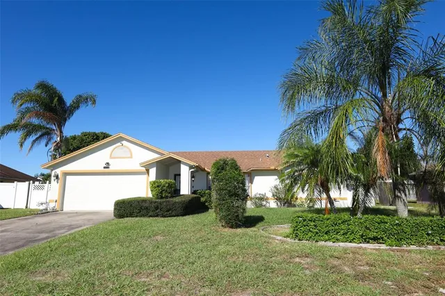 a view of house with a yard and palm trees