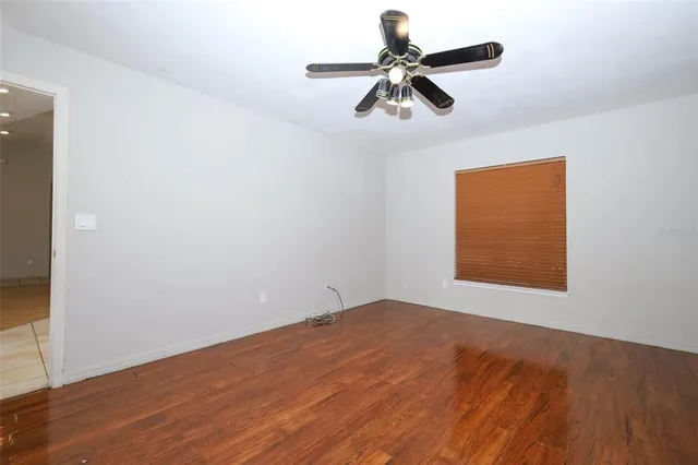 an empty room with a window and a ceiling fan
