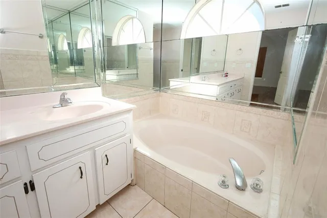 a bathroom with a tub sink and mirror