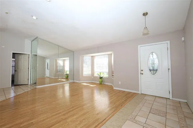 a view of an empty room with window and wooden floor