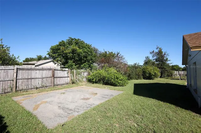 a view of a yard in front of a house with a large tree