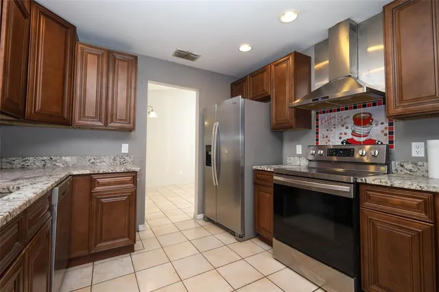 a kitchen with stainless steel appliances granite countertop a stove a refrigerator and a sink