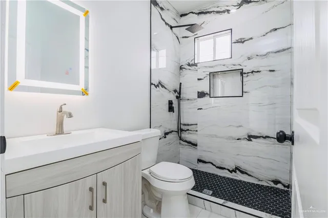 a bathroom with a sink a toilet and shower