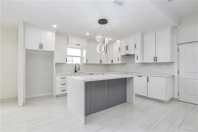 a kitchen with white cabinets stainless steel appliances and a window