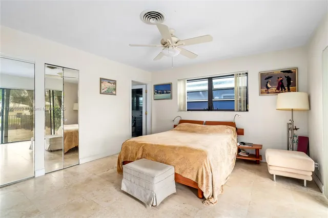 a spacious bedroom with a bed a window and a chandelier