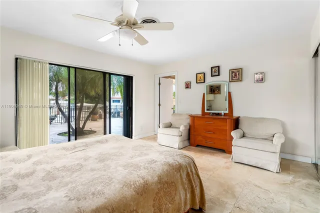 a bedroom with a large bed couch and a large window