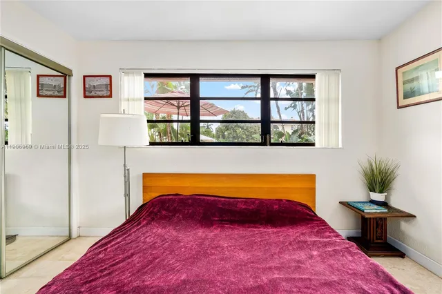 a bedroom with a bed and a potted plant next to a window