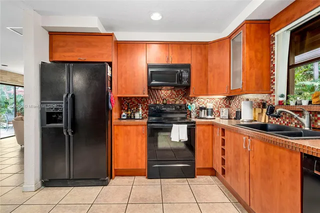 a kitchen with stainless steel appliances granite countertop a refrigerator and a sink
