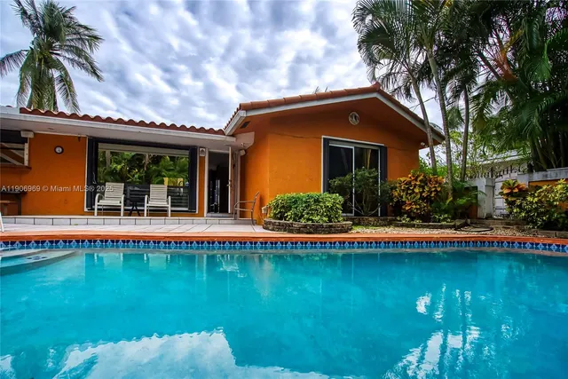 a view of a house with swimming pool and a yard
