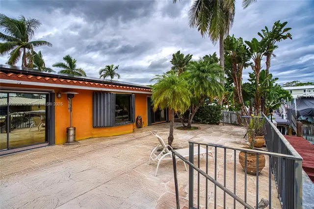 a view of a patio with a table and chairs under an umbrella