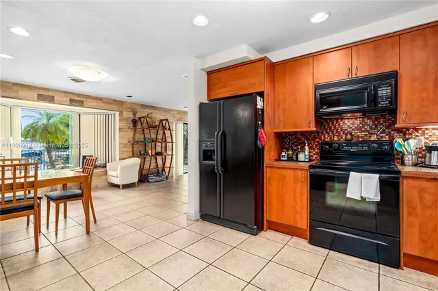 a kitchen with stainless steel appliances kitchen island granite countertop a refrigerator and a stove top oven