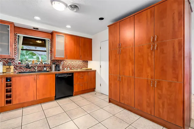 a kitchen with stainless steel appliances granite countertop wooden cabinets a sink and a counter top space