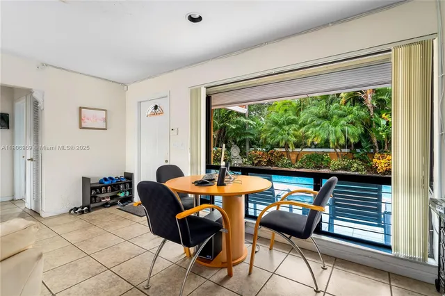 a dining room with furniture and a large window
