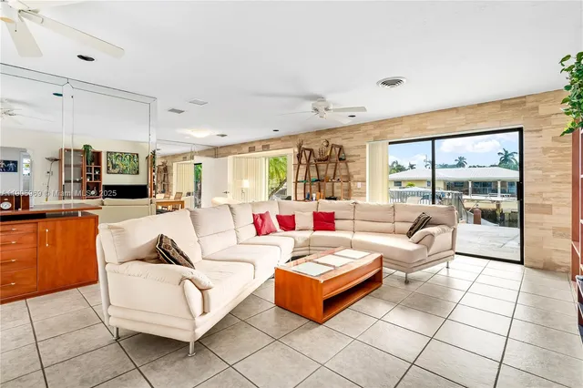a living room with patio furniture and a large window