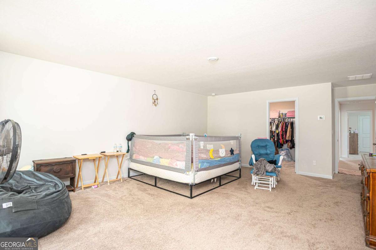 653 Meadows Farm Way Monroe, GA 30655 - Photo 20 of 34 a bed room with a bed and a chair
