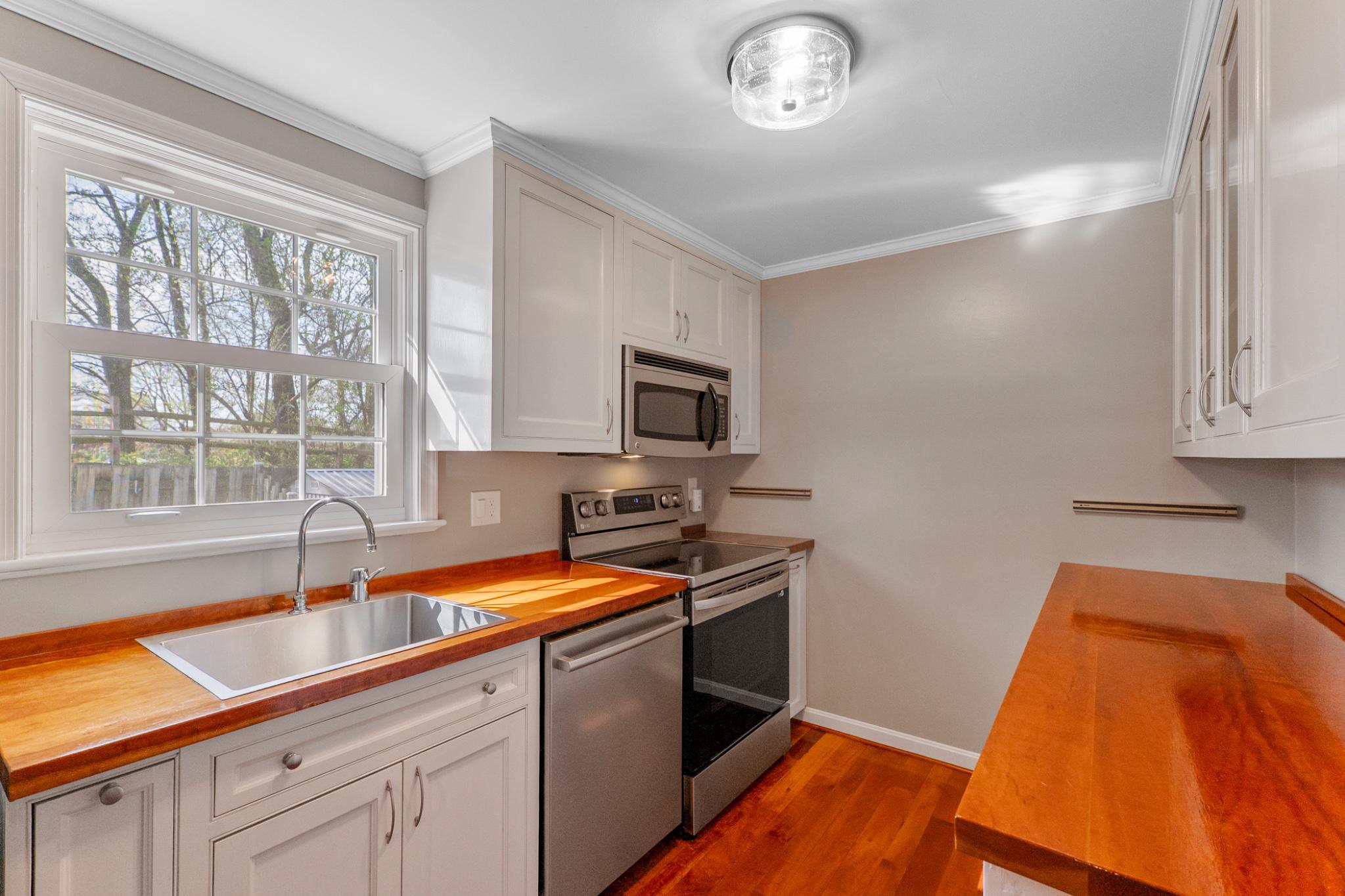 9918 Canvasback Way Damascus, MD 20872 - Photo 10 of 32 a kitchen with stainless steel appliances granite countertop a sink a stove and a microwave