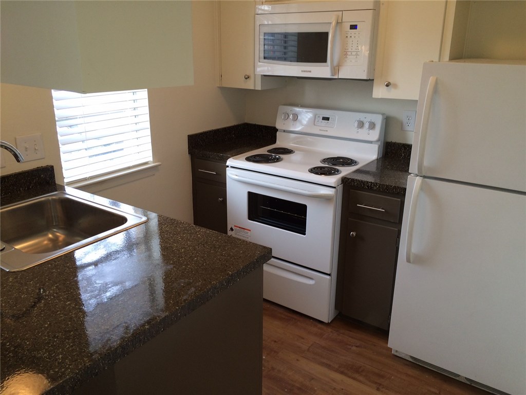 4503 Speedway, Unit 108 Austin, TX 78751 - Photo 1 of 1 a kitchen with a stove microwave and refrigerator