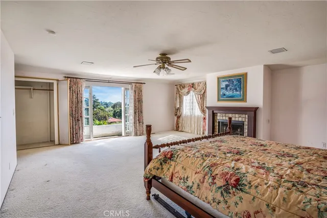 a bed sitting in a spacious bedroom next to a window