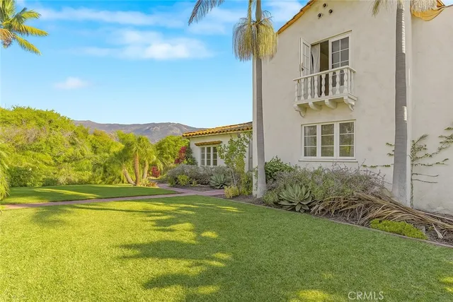 a view of a house with a big yard and potted plants