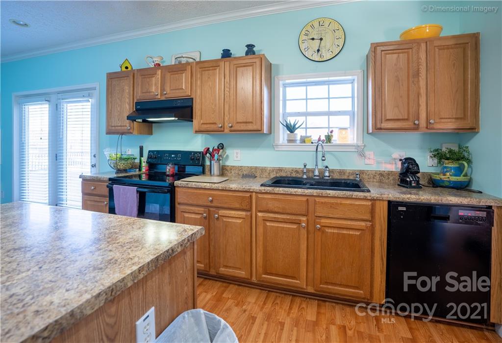 1117 North Ridge Road Hendersonville, NC 28792 - Photo 13 of 35 a kitchen with stainless steel appliances granite countertop a sink a stove and wooden cabinets