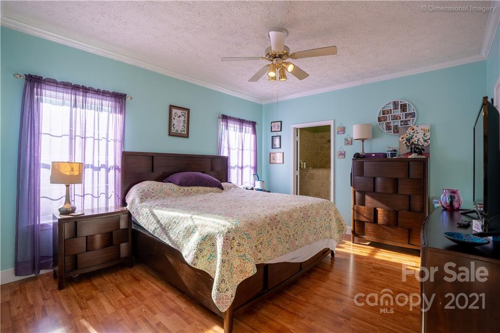 1117 North Ridge Road Hendersonville, NC 28792 - Photo 17 of 35 a bedroom with a bed and dresser with wooden floor