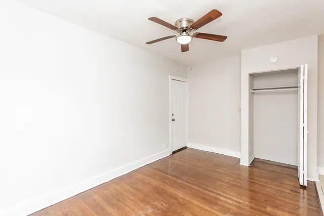 a view of a big room with wooden floor and a ceiling fan