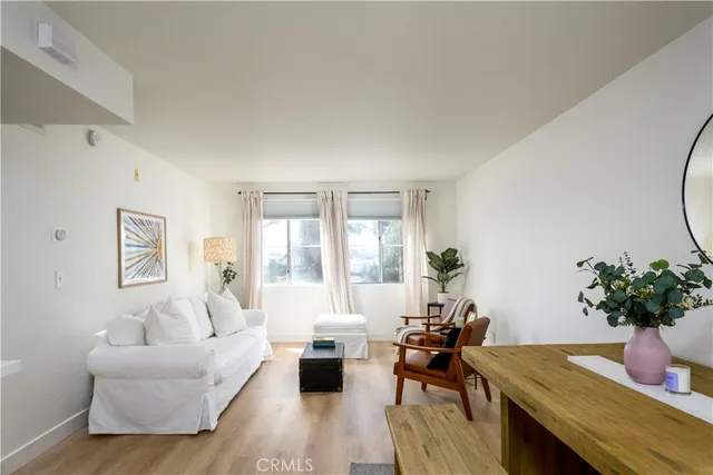 a living room with furniture floor to ceiling window and potted plant