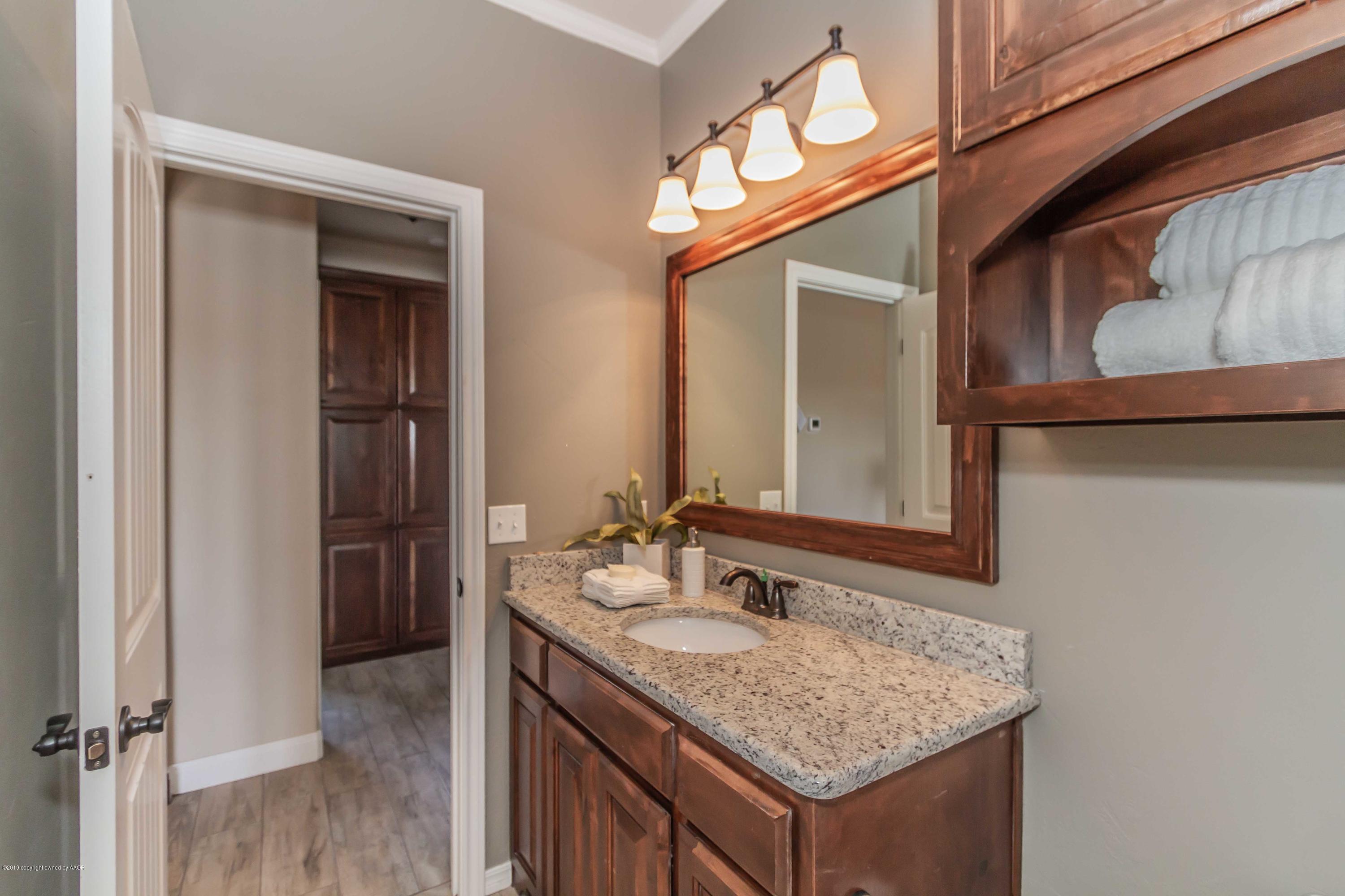 9801 Help Lane Amarillo, TX 79119 - Photo 40 of 46 a bathroom with a granite countertop sink and a mirror