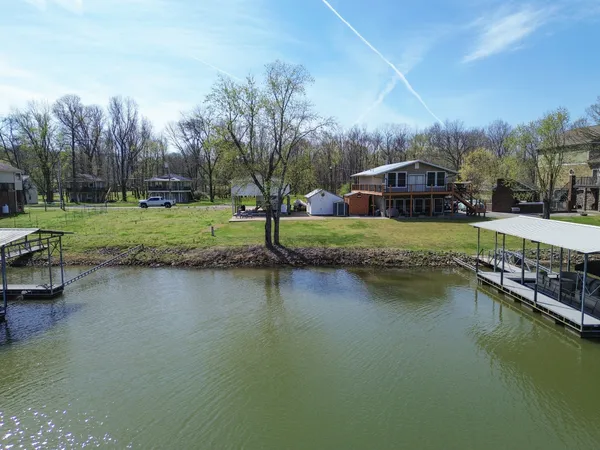 a front view of a house with a yard and lake view
