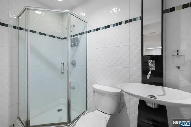 a bathroom with a shower a toilet and sink